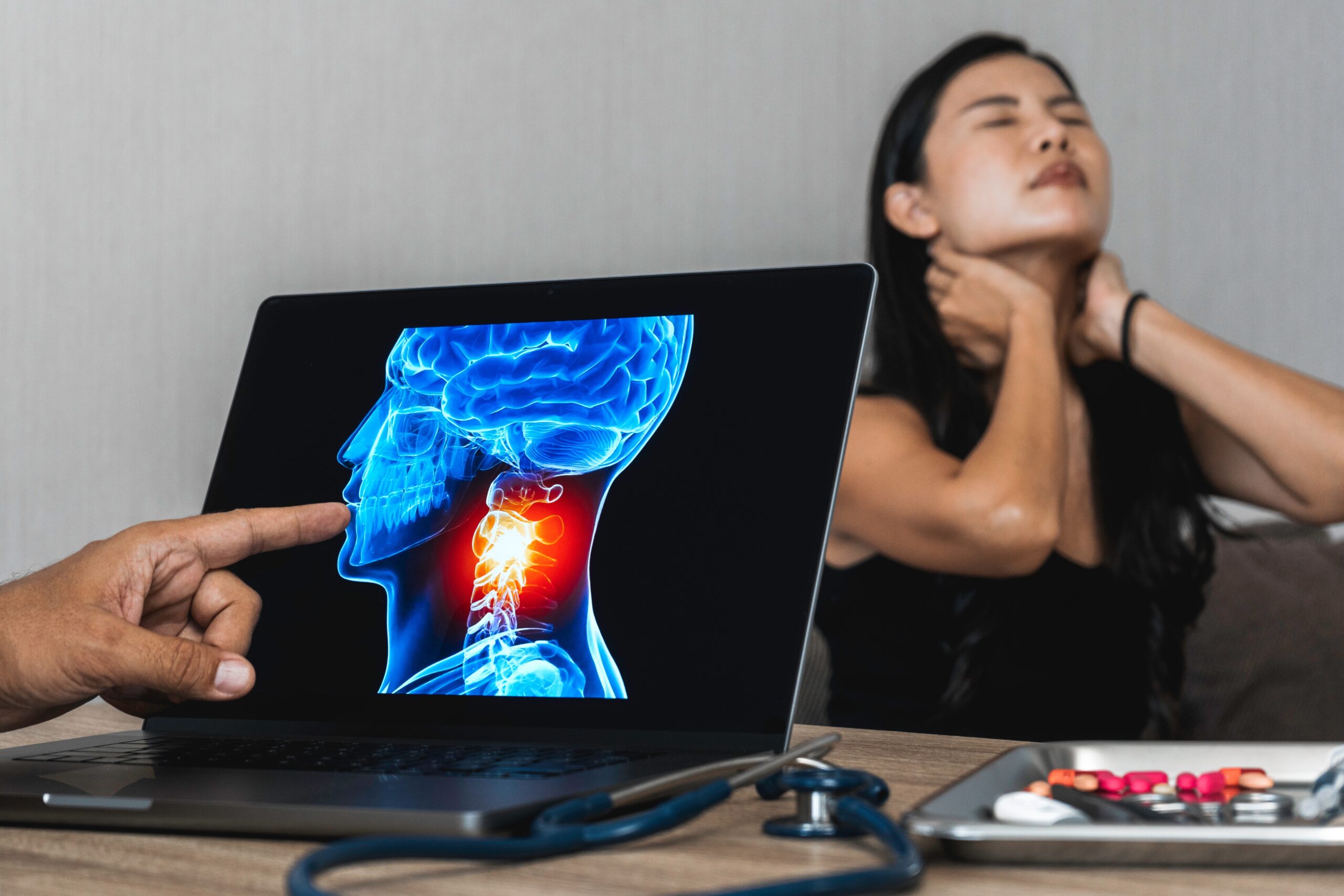 A doctor examines a patient's neck and reviews an x-ray while discussing specialized cervical disc fusion procedures.