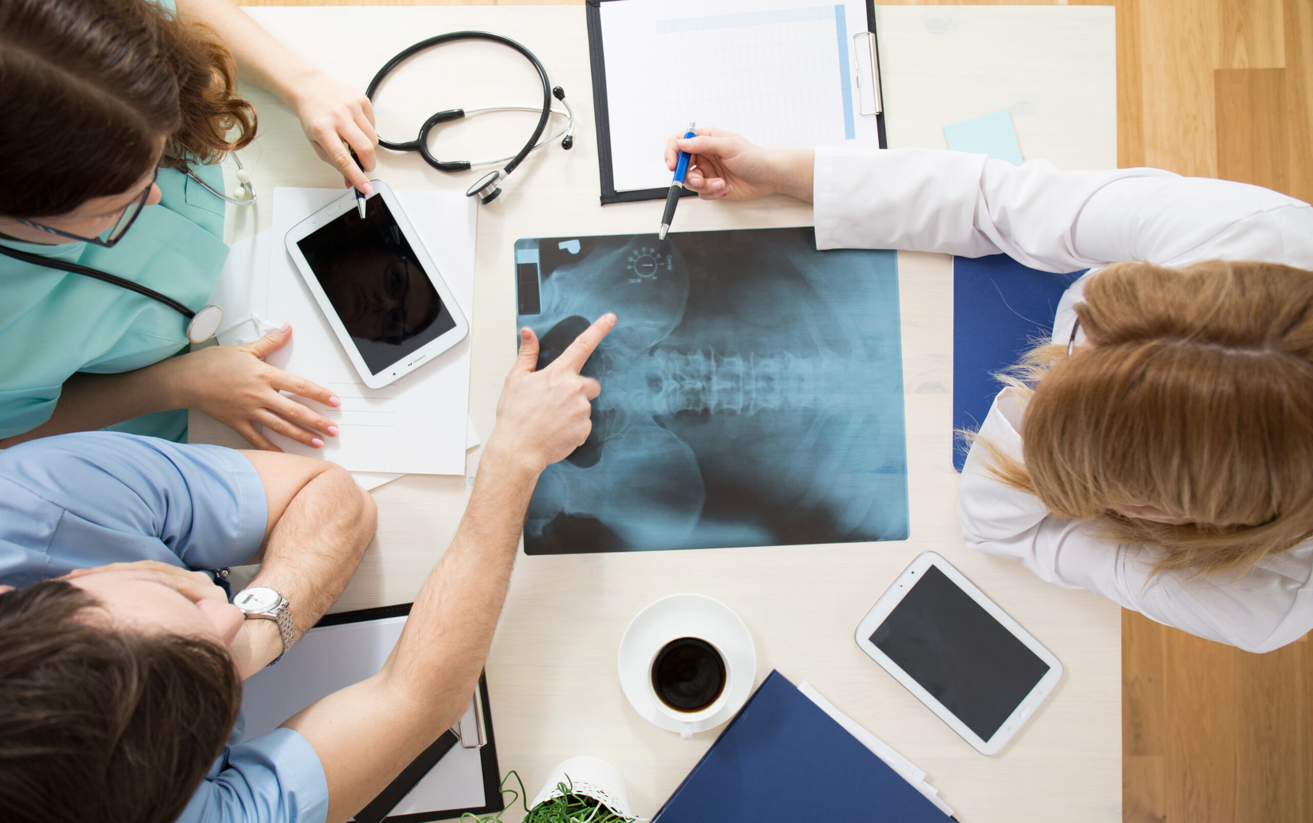 A spinal doctor talking with patients, reviewing a spinal x-ray together.